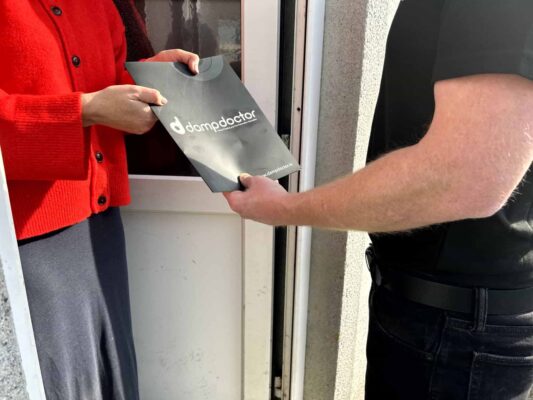 Dampdoctor.ie - Engineer handing damp survey report over to happy customer - Condensation, Mould & Ventilation Solutions