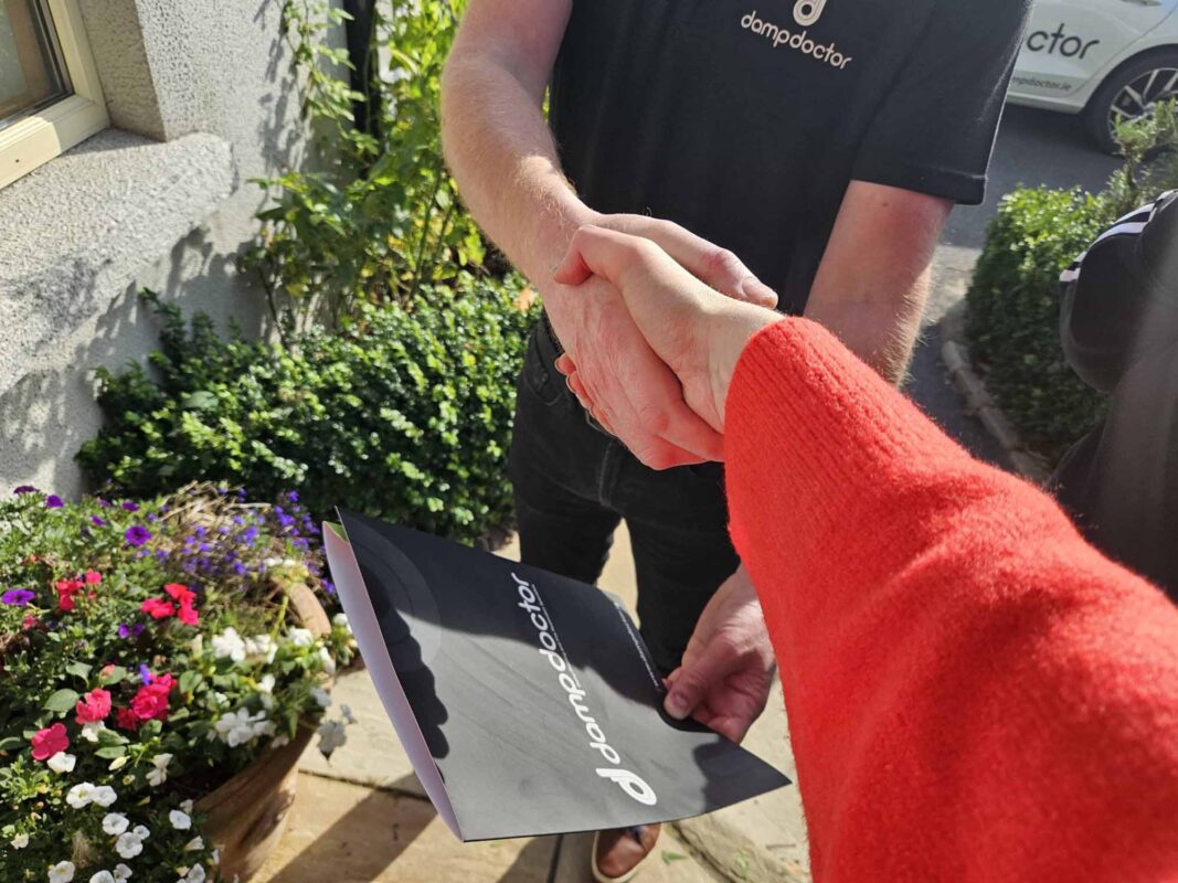 Dampdoctor.ie - Surveyor handing report over to happy customer and shaking hands outside
